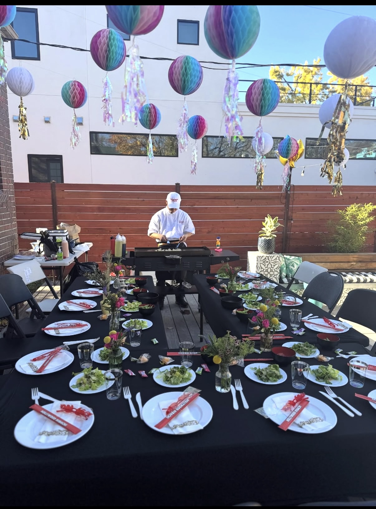 Hibachi grill and tables beneath colorful party decorations