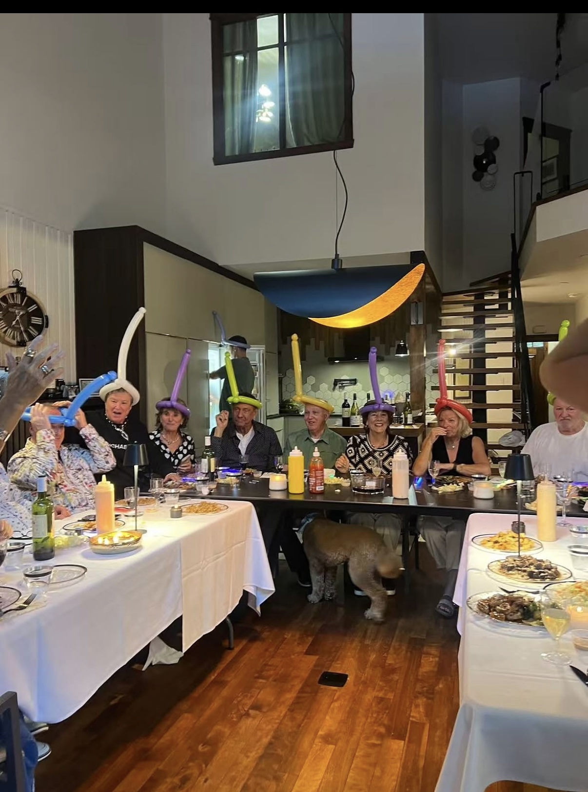 Dinner guests wearing colorful balloon hats